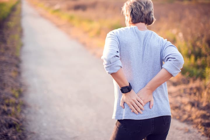 a woman holding her painful back