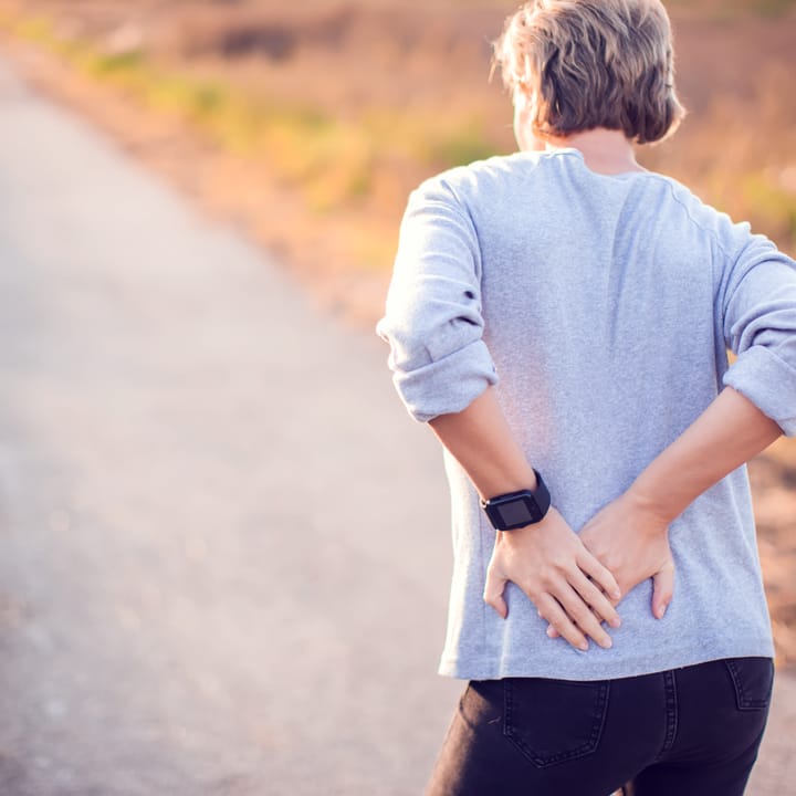 a woman holding her painful back
