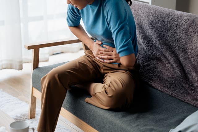 Woman pressing her hands to stomach
