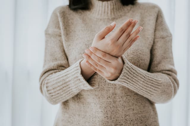 a woman holding her painful wrist