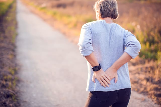 a woman holding her painful back